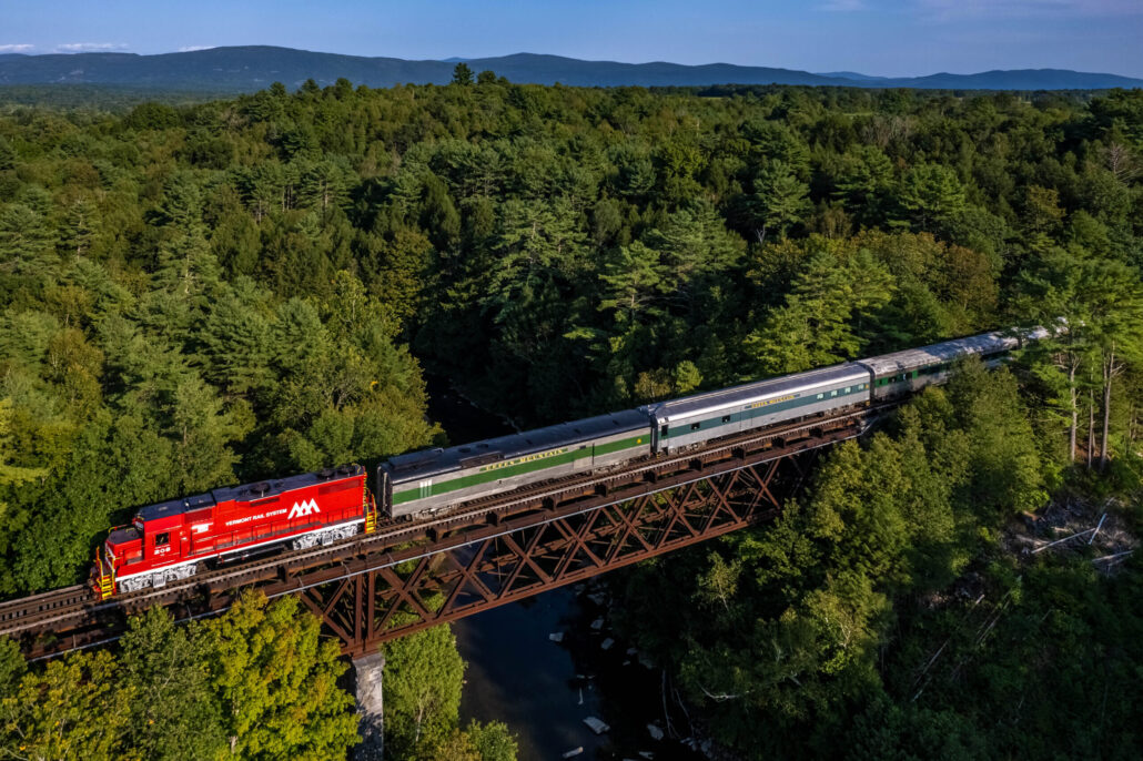 rails-vt_champlain-valley-dinner-train-train-bridge-forest-mountains Rails Vt Champlain Valley Dinner Train Train Bridge Forest Mountains